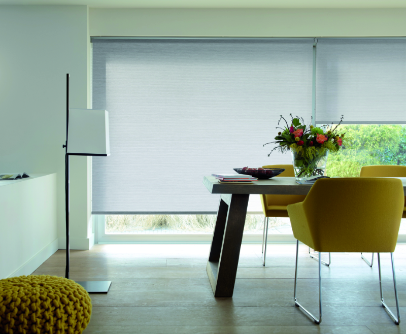 Wohnzimmer mit Plissee am Fenster, im Vordergrund ein gelber Stuhl